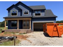Two-story home features blue siding, a covered porch and a two-car garage at 240 Noramac Ct, Selma, NC 27576
