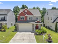 Charming two-story home featuring a two-car garage, well-maintained lawn and beautiful landscaping at 274 Marsh Creek Dr, Garner, NC 27529