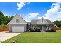 Charming home featuring a well-manicured lawn, two-car garage, and inviting front porch with rocking chairs at 282 Brodie Rose Landing Way, Smithfield, NC 27577