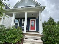 Charming home featuring a vibrant red front door and a welcoming porch with white columns at 283 Daniel Ridge Rd, Wendell, NC 27591