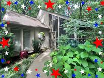 Charming home featuring a screened porch and landscaped front yard, nestled among lush trees at 2900 Sylvania Dr, Raleigh, NC 27607