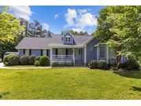 Charming blue house with a well-manicured lawn and tasteful landscaping at 304 Foxcroft Dr, Timberlake, NC 27583