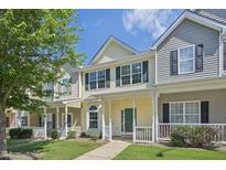 Inviting two-story townhome with green front door and charming front porch and well-manicured lawn at 3973 Volkswalk Pl, Raleigh, NC 27610