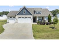 Charming home with a spacious three-car garage and well-maintained front yard at 50 N Nolan Park Dr, Selma, NC 27576