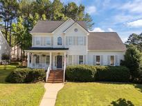 Charming two-story home featuring a covered front porch and well-manicured landscaping at 513 Moultonboro Ave, Wake Forest, NC 27587