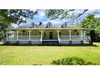 Charming home with a covered porch, dormer windows, and lush green lawn at 6600 Sadie Dr, Wendell, NC 27591