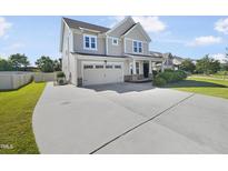 Charming two-story home boasts a well-manicured lawn, long driveway and an attached two-car garage at 1092 Adams Point Dr, Garner, NC 27529