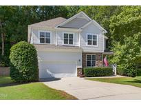 Charming two-story home features a stone facade, attached garage, and an inviting, landscaped front yard at 1437 Lindenberg Sq, Wake Forest, NC 27587