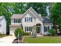 Charming home featuring a landscaped yard, architectural details, and attached garage, creating inviting curb appeal at 208 Silk Hope Dr, Cary, NC 27519