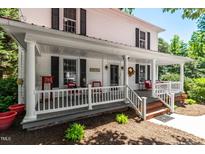 Inviting white front porch with classic columns, comfortable seating, and a charming, welcoming atmosphere at 210 Peachtree St, Roxboro, NC 27573