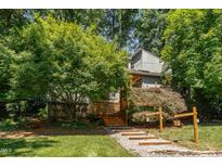 Beautiful exterior with wood stairs and landscaping, surrounded by mature trees, offering a serene setting at 28 Benchmark, Pittsboro, NC 27312