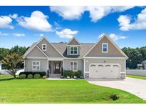 Charming home boasts a two-car garage, landscaped yard, and inviting front entrance at 308 Nashville Dr, Archer Lodge, NC 27527