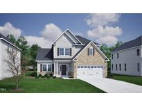 Inviting two-story home featuring a mix of brick and siding, complemented by a well-manicured lawn at 343 Augusta Pond Way # 176, Raleigh, NC 27603
