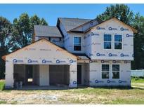 Two story home under construction shows open garage and installed windows on a sunny day at 3881 Josiah Ct, Nashville, NC 27856