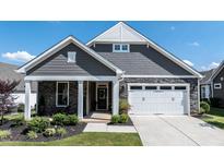 Charming exterior features a stone facade, gray siding, and a well-manicured lawn at 405 Bramble Ln, Clayton, NC 27527