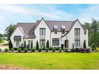 Stunning two-story painted brick home with professionally landscaped front yard and beautiful architectural details at 7304 Wexford Woods Ln, Wake Forest, NC 27587