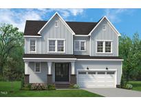Charming two-story home with light blue siding, a covered porch, and an attached garage at 812 Ballaster Rd, Fuquay Varina, NC 27526