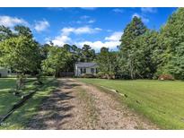 Charming single-story home featuring a well-maintained lawn, gravel driveway, and inviting curb appeal at 109 Mill Creek Dr, Youngsville, NC 27596
