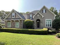 Charming home featuring stone and shingle exterior with manicured lawn, trimmed bushes and inviting front entrance at 1316 Plunket Dr, Wake Forest, NC 27587
