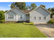 Charming single-story home with light siding, a well-manicured lawn, and mature trees at 1401 Burchcrest Dr, Garner, NC 27529