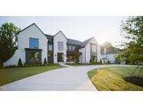 Stunning two-story white brick home with black trim, large windows and a circular driveway at 1620 Hunting Ridge Rd, Raleigh, NC 27615