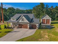 Inviting two-story home features a 3-car garage, additional detached garage and a well-manicured lawn at 178 Greenwich Dr, Sanford, NC 27330