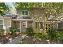 Charming home featuring a well-maintained exterior, lush landscaping, and a welcoming entrance adorned with potted flowers at 303 Applecross Dr, Cary, NC 27511