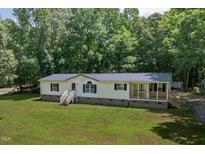 Inviting single Gathering home with a covered porch and freshly cut lawn surrounded by lush trees at 40 Raccoon Xing, Henderson, NC 27537