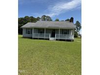 Charming single story home features a covered porch and lush green lawn at 410 Carmil Dr, Selma, NC 27576