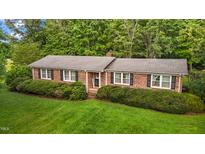 Charming brick home featuring black shutters, manicured landscaping, and lush green lawn at 4345 Mcintyre Rd, Gibsonville, NC 27249
