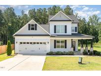 Charming two-story home with white siding, black shutters, a two-car garage, and a well-manicured lawn at 454 Martins Mill Ct, Wendell, NC 27591