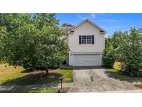 Two story home featuring a large front yard, attached garage, and lovely curb appeal at 4716 Miller Dr, Durham, NC 27704