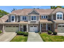 Charming townhome with brick accents, two-car garage, and well-maintained landscaping at 8323 Yaxley Hall Dr, Raleigh, NC 27616