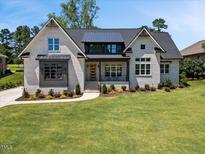 Charming painted brick home with a manicured lawn and a welcoming front porch at 940 Rivers Edge Dr, Graham, NC 27253