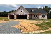 New construction home with black roof, framed windows, and an attached, unfinished two-car garage at 171 Surles Landing Way, Benson, NC 27504