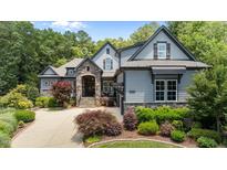 Stunning exterior of home with stone accents, landscaped yard, and driveway leading to the garage at 2112 Colin Hill Ct, Wake Forest, NC 27587