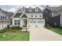 Beautiful two-story home featuring a two-car garage and a well-manicured lawn at 237 Emory Bluffs Dr, Holly Springs, NC 27540