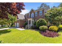 Charming brick two-story home featuring a well-manicured lawn and lush landscaping at 308 Sutton Glen Dr, Apex, NC 27523