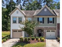 Charming two-story townhome with stone accents, attached garages, and a well-maintained lawn at 3810 Prince Noah Loop, Wake Forest, NC 27587