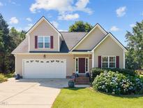 Charming two-story home with a well-manicured lawn, attached garage, and inviting front porch at 545 Olivia Way, Selma, NC 27576