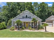 Charming home featuring a yellow front door, landscaped yard, and a well-manicured lawn and beautiful trees at 101 Ferndale Ct, Clayton, NC 27520