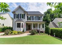 Charming two-story home featuring a well-manicured lawn, a front porch, and dark blue shutters at 1830 Wilshire Ave, Raleigh, NC 27608