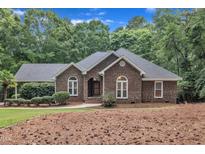 Charming brick home with arched windows, mature landscaping, and a welcoming front entrance at 2095 Woodberry Dr, Clayton, NC 27527