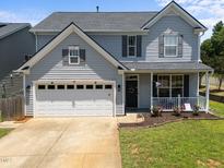 Charming two-story home with a two-car garage, a front porch and a well-maintained lawn at 300 Stobhill Ln, Holly Springs, NC 27540