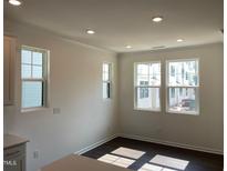 Bright dining area with hardwood floors and multiple windows allowing ample natural light at 3113 White Blossom Ct, Raleigh, NC 27610