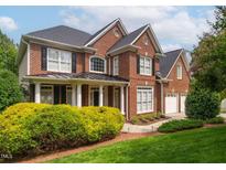 Beautiful brick two-story home with black shutters, white trim, manicured lawn, and mature landscaping at 315 Birdwood Ct, Cary, NC 27519