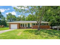 Charming brick home featuring an attached garage and a well-maintained lawn with mature trees at 430 Walnut St, Cary, NC 27511