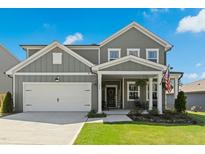 Charming two-story home with gray siding, a welcoming front porch, and a well-maintained front lawn at 444 Campbell Ridge Pl, Wendell, NC 27591