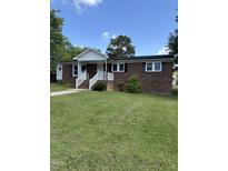 Charming brick home featuring a welcoming entrance and a well-manicured front yard with lush green grass at 501 Morgan Ter, Burlington, NC 27217