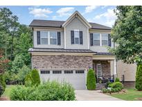 Charming two-story home featuring stone accents, a two-car garage, and landscaped front yard at 1020 Regency Cottage Pl, Cary, NC 27518
